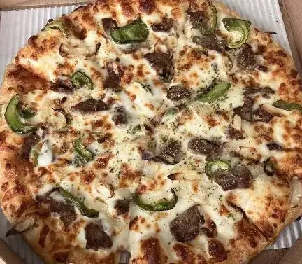 A pizza with meat and peppers in a box.